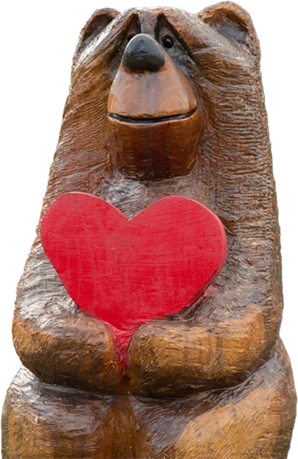 Carved wooden bear statue holding a red heart.