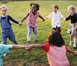 Children holding hands in a circle outdoors