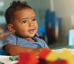 Smiling toddler playing with blocks