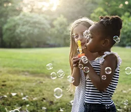 Girls blowing bubbles outside