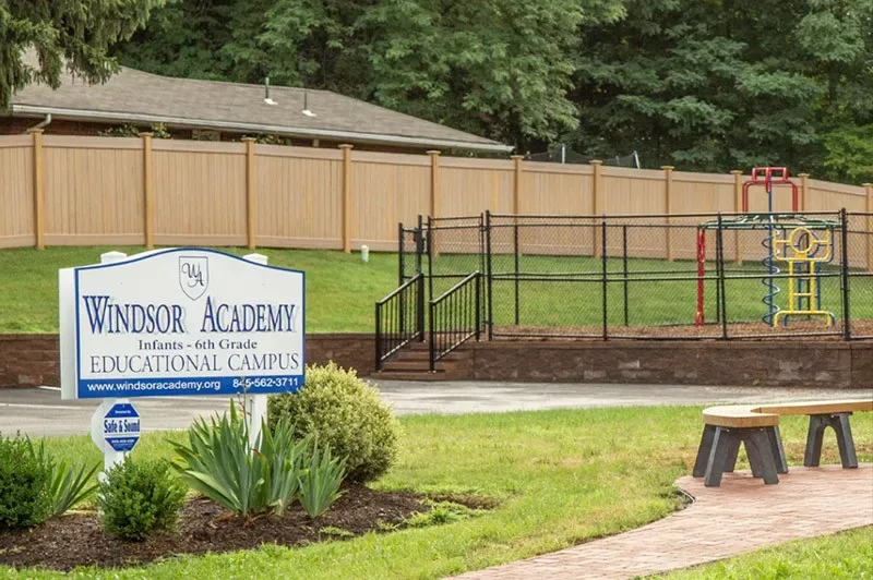 Windsor Academy sign with a playground in the background.