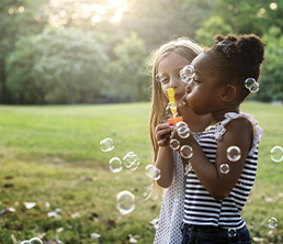 Summer Program: Two girls blowing bubbles